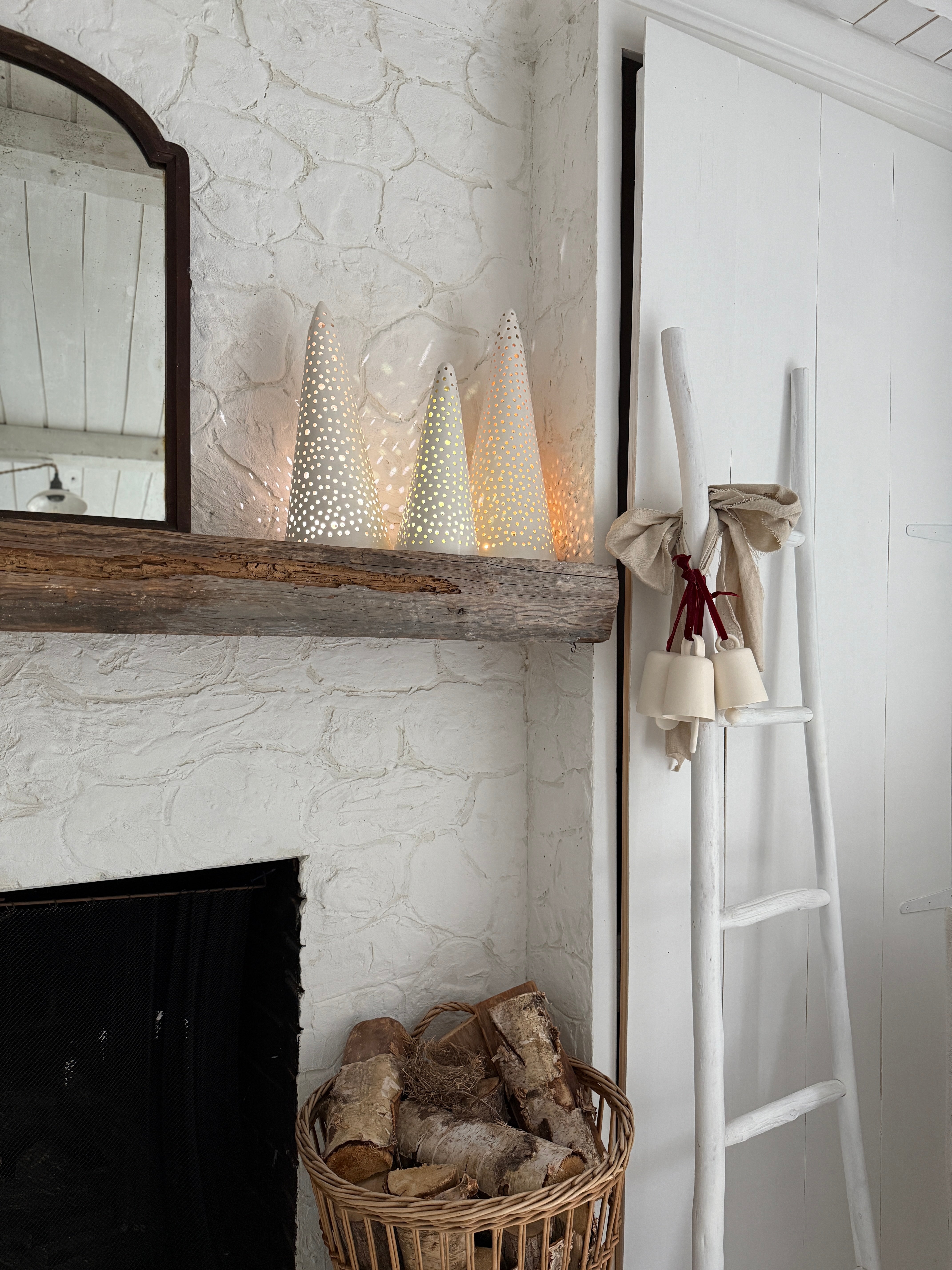 Handmade stoneware tree luminary with star cutouts glowing from an LED tea light