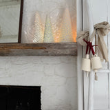 Handmade stoneware tree luminary with star cutouts glowing from an LED tea light