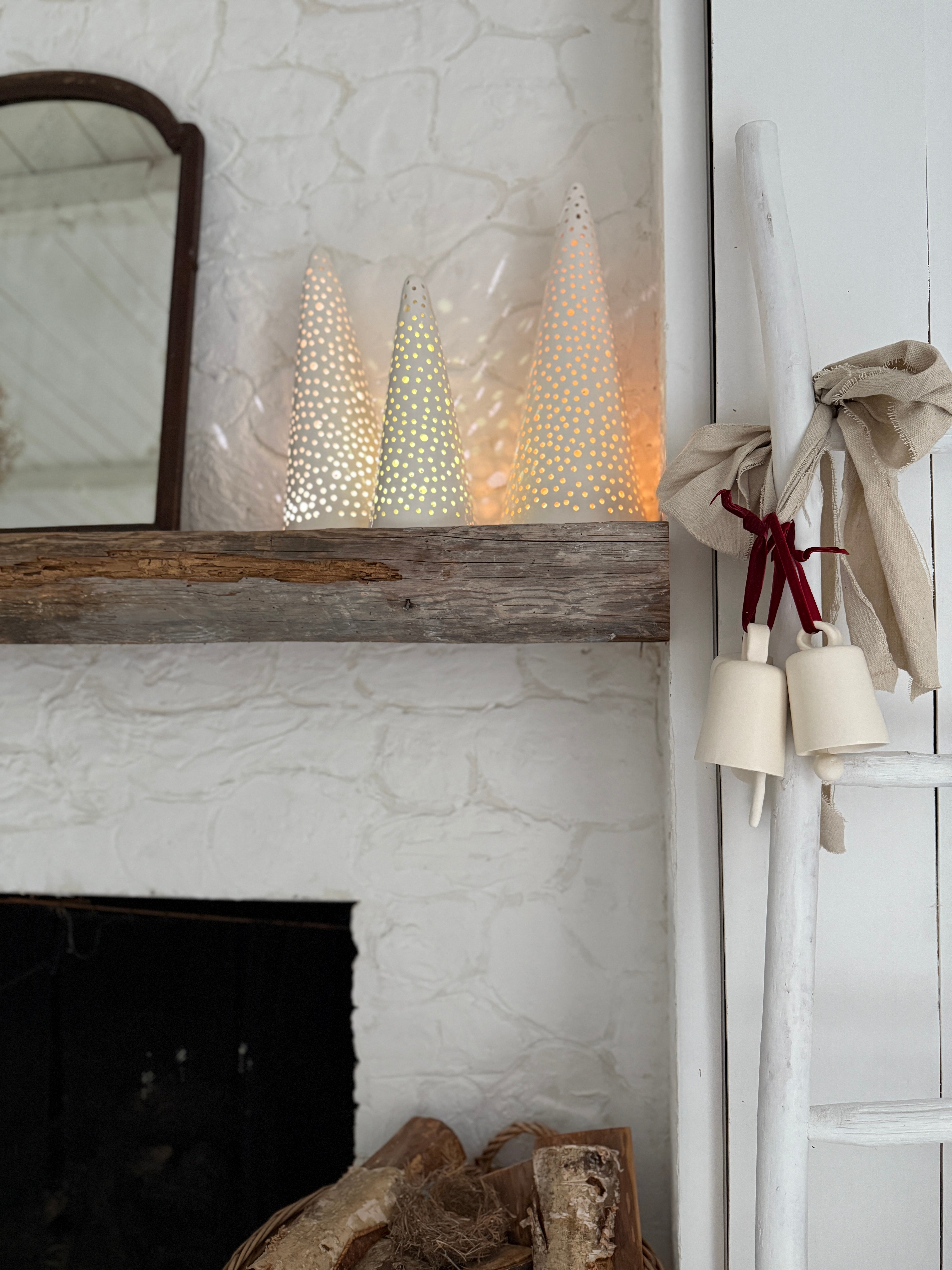 Handmade stoneware tree luminary with star cutouts glowing from an LED tea light