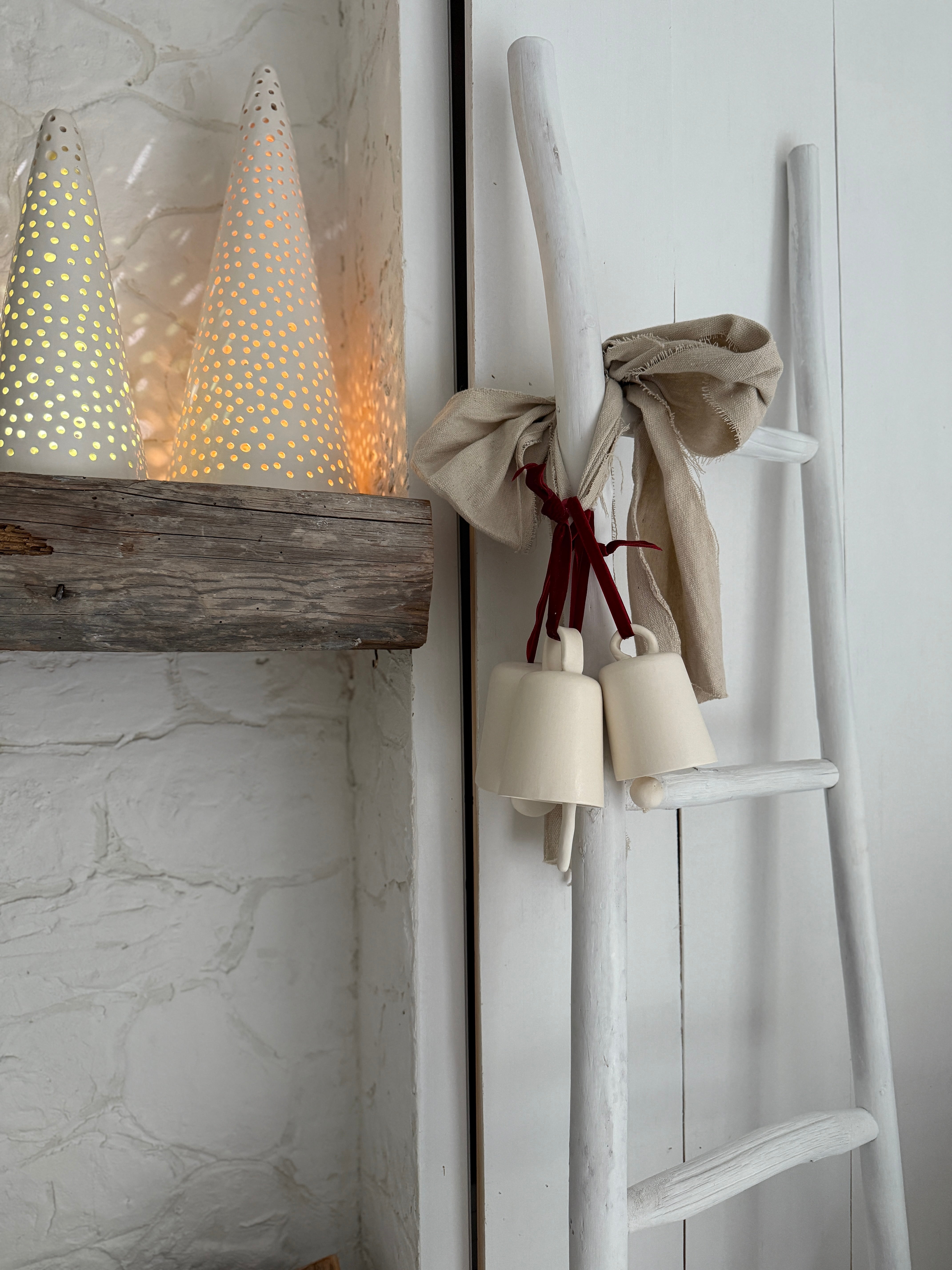 Handmade stoneware tree luminary with star cutouts glowing from an LED tea light