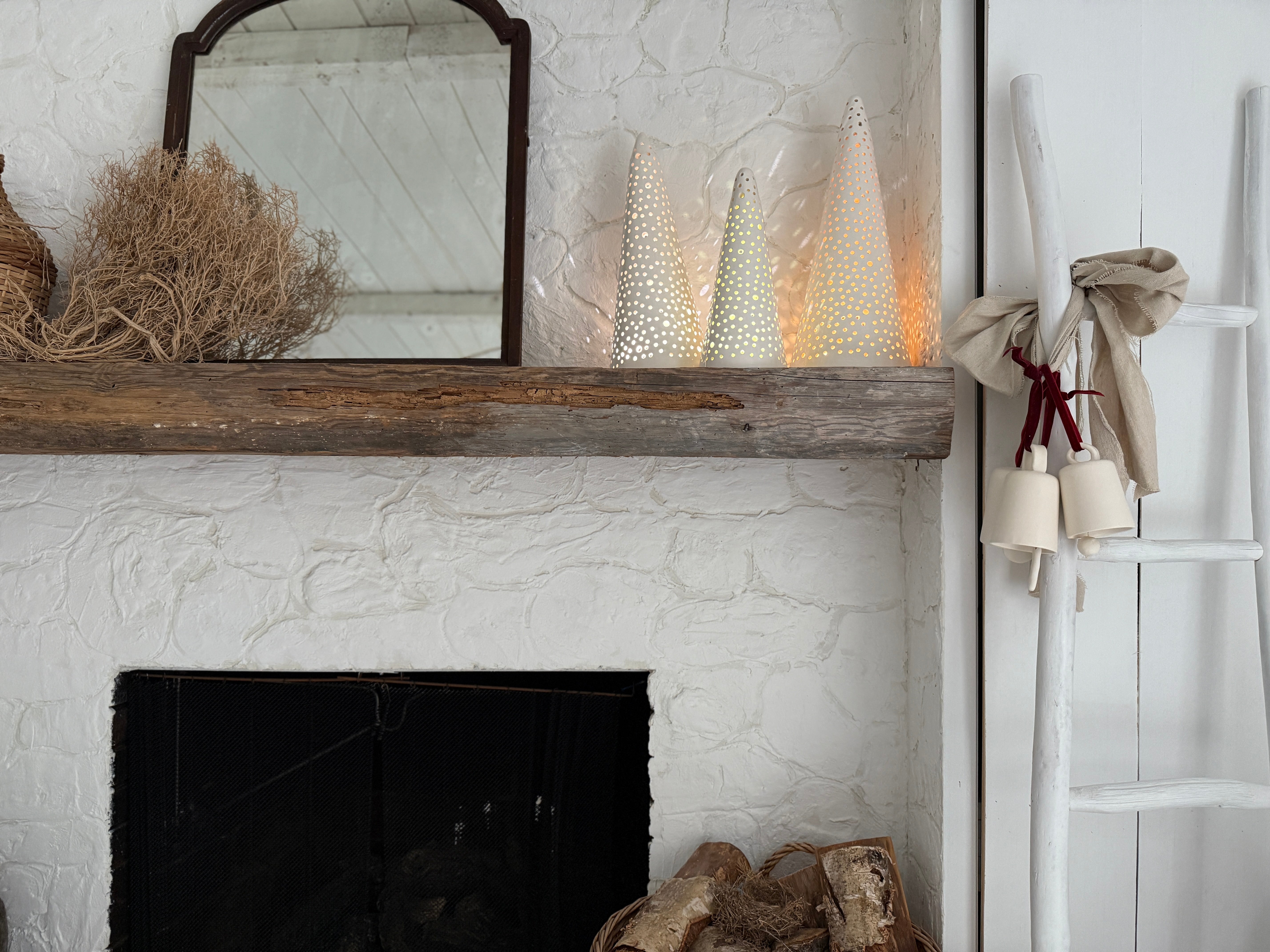 Handmade stoneware tree luminary with star cutouts glowing from an LED tea light