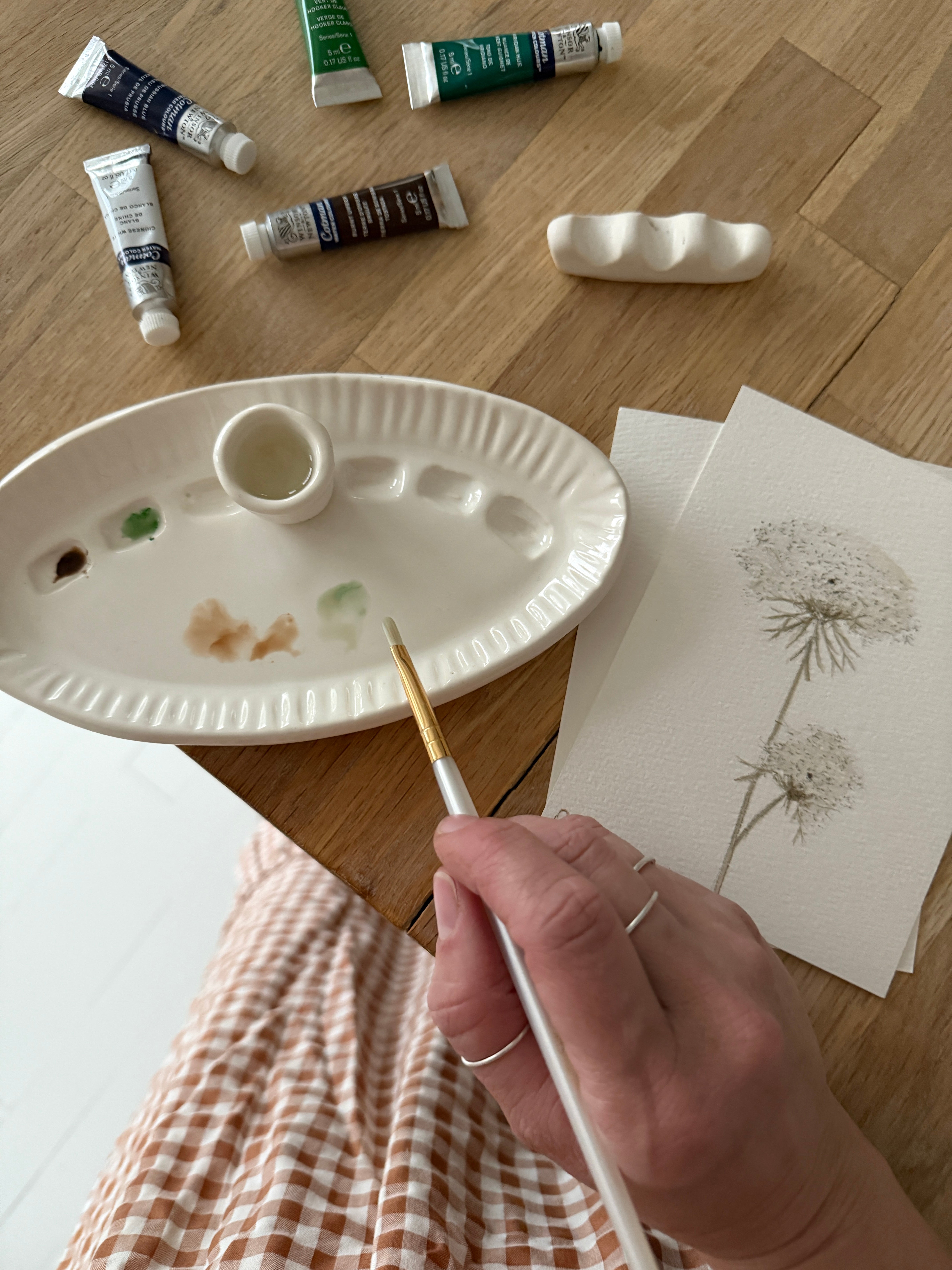 Handmade ceramic watercolor paint palette with mixing wells, a small water cup, and a brush holder.