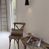 Handmade conical ceramic wall sconce with a clean cone silhouette on a wall