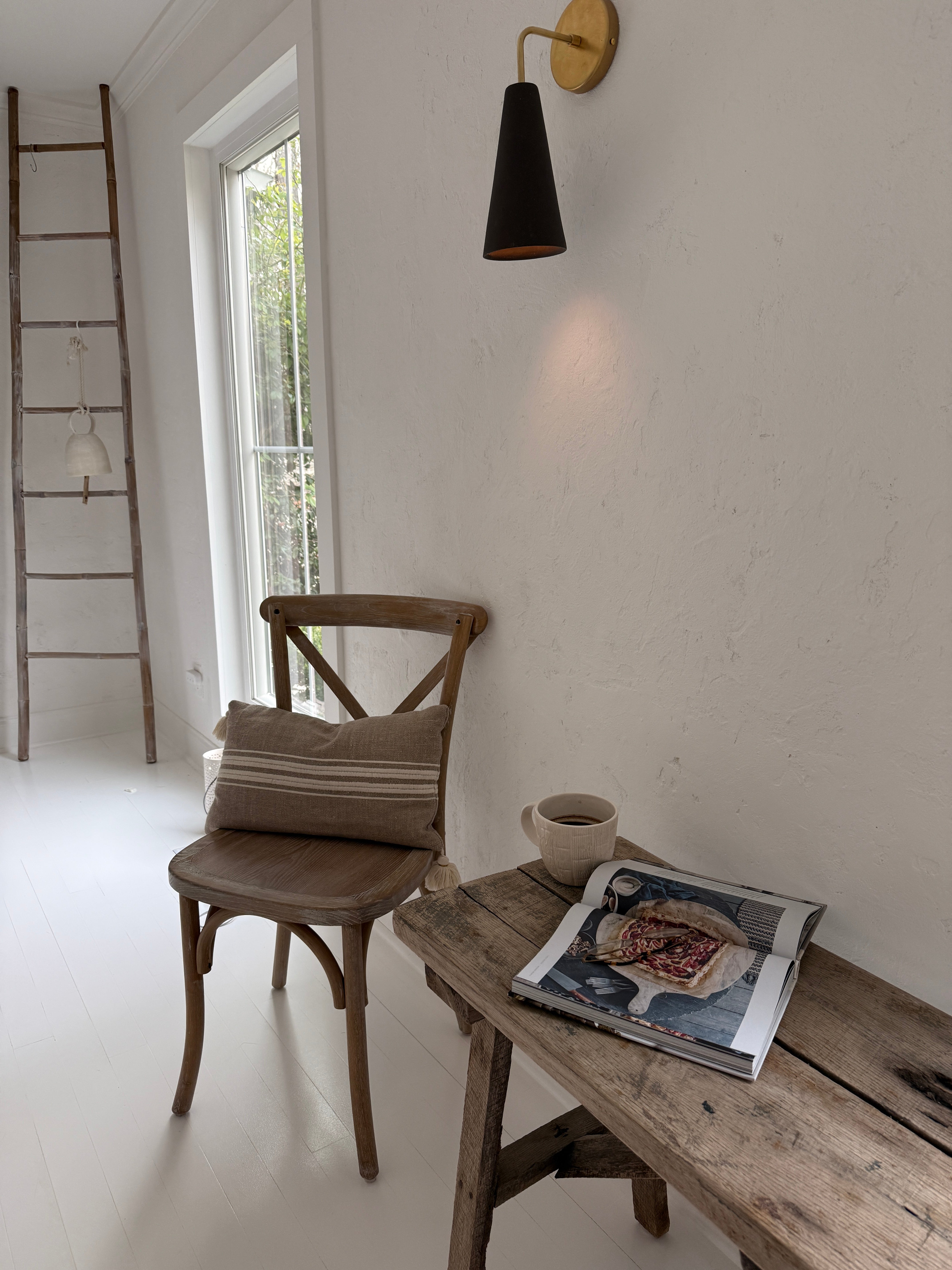 Handmade conical ceramic wall sconce with a clean cone silhouette on a wall