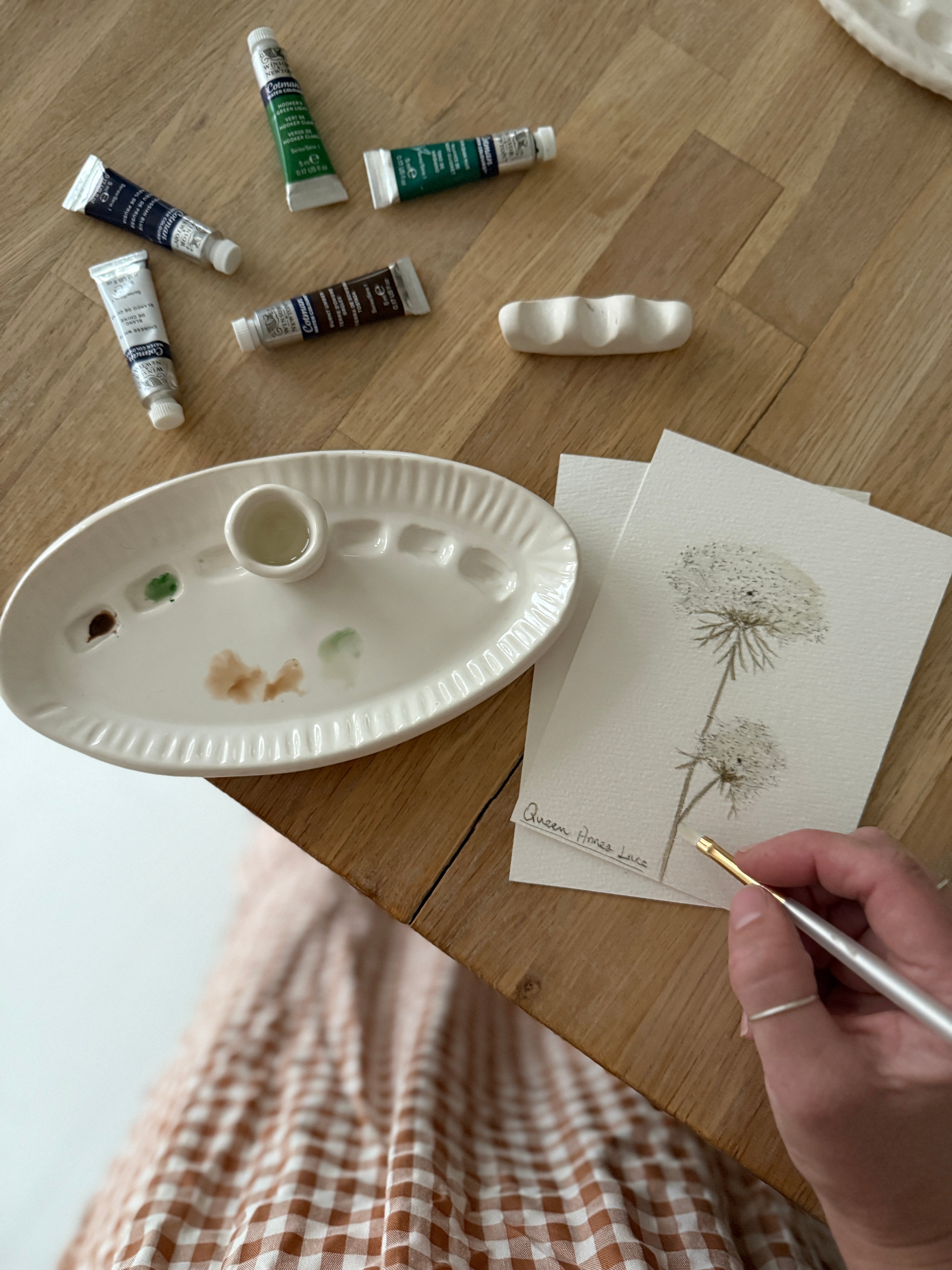 Handmade ceramic watercolor paint palette with mixing wells, a small water cup, and a brush holder.