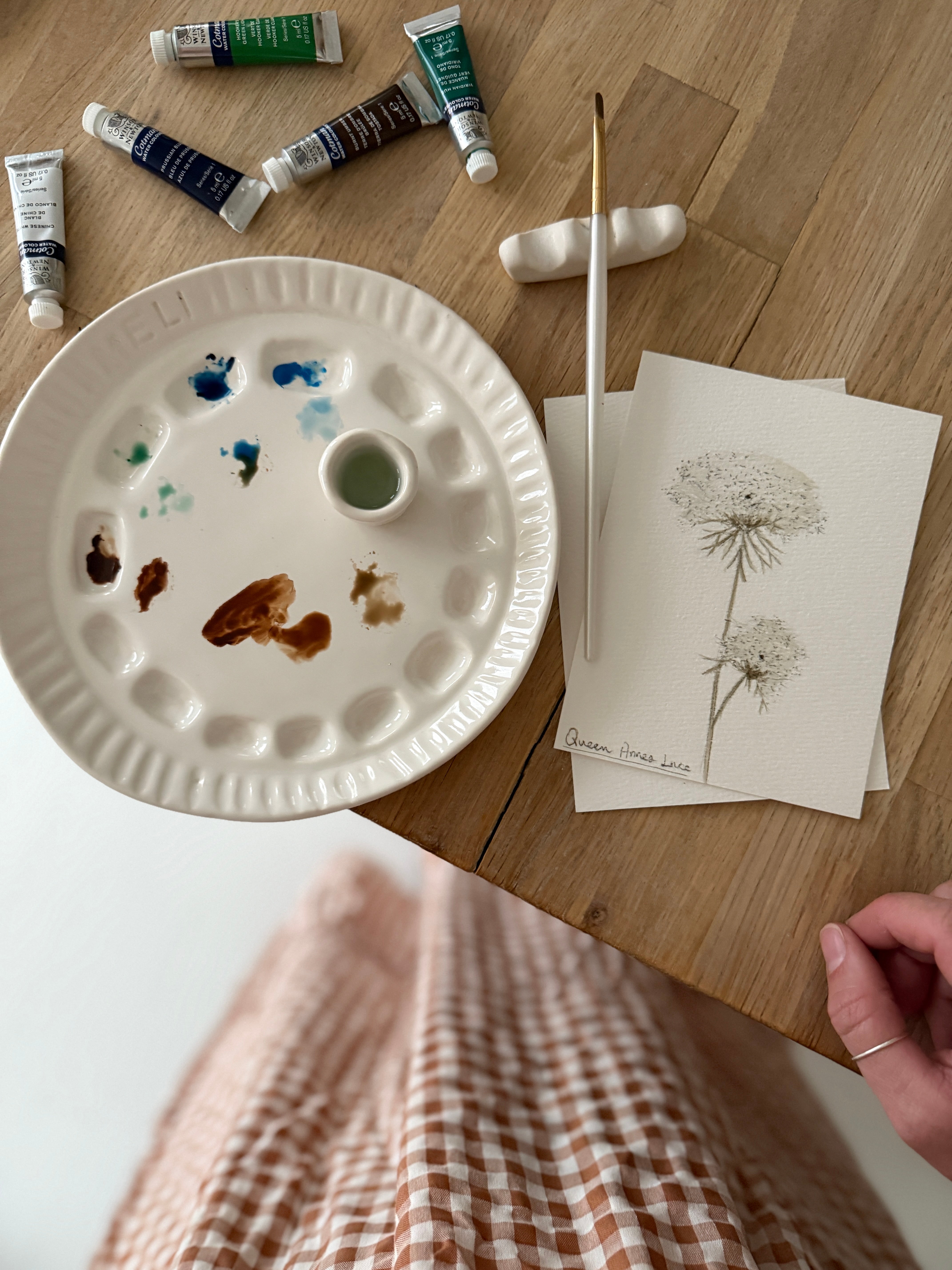 Handmade ceramic watercolor paint palette with mixing wells, a small water cup, and a brush holder.
