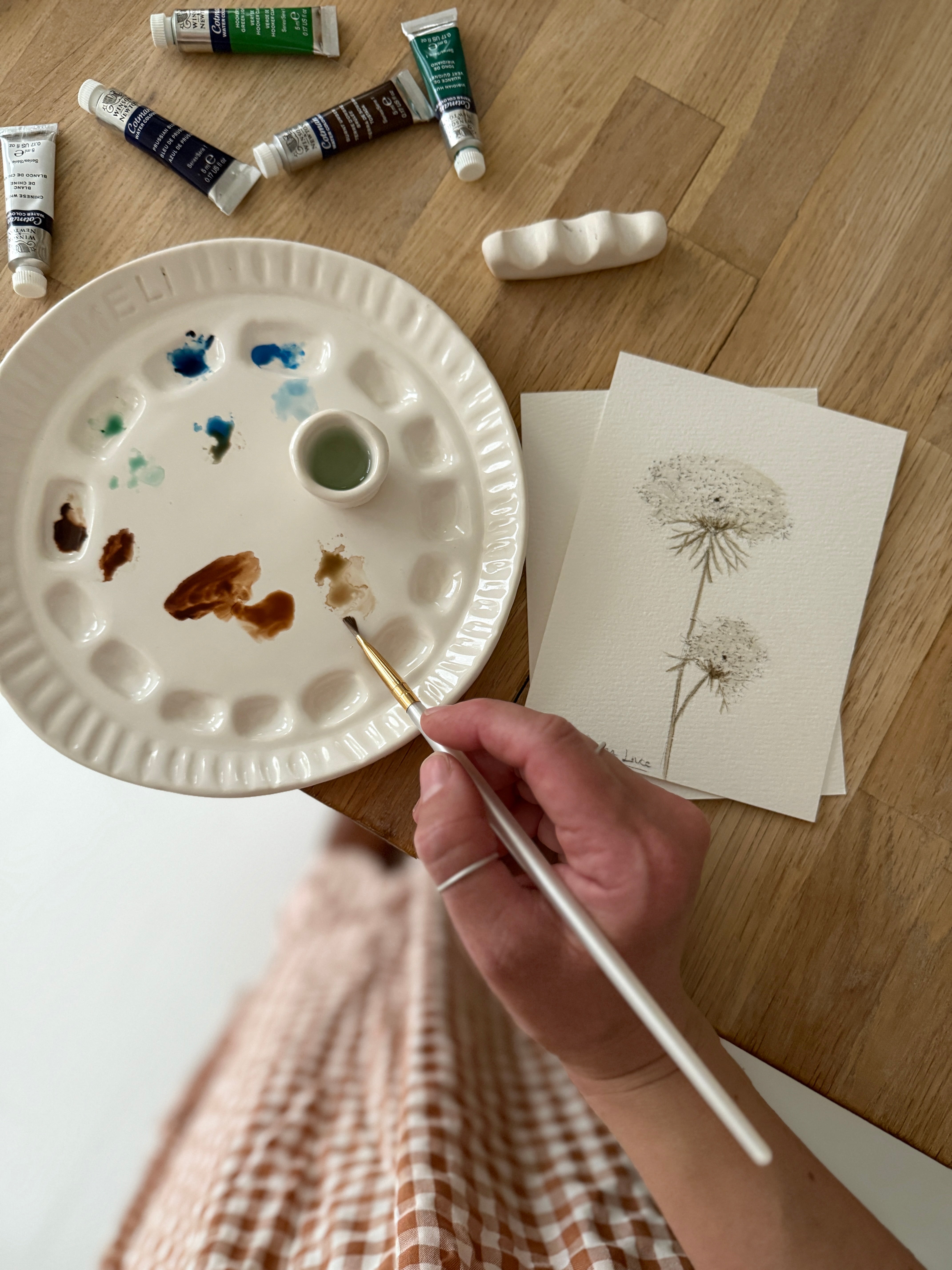Handmade ceramic watercolor paint palette with mixing wells, a small water cup, and a brush holder.