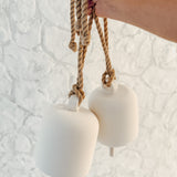 Handmade ceramic Loki bell in a neutral finish, hung for indoor or covered outdoor decor