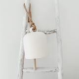 Handmade ceramic Loki bell in a neutral finish, hung for indoor or covered outdoor decor