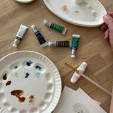 Handmade ceramic watercolor paint palette with mixing wells, a small water cup, and a brush holder.