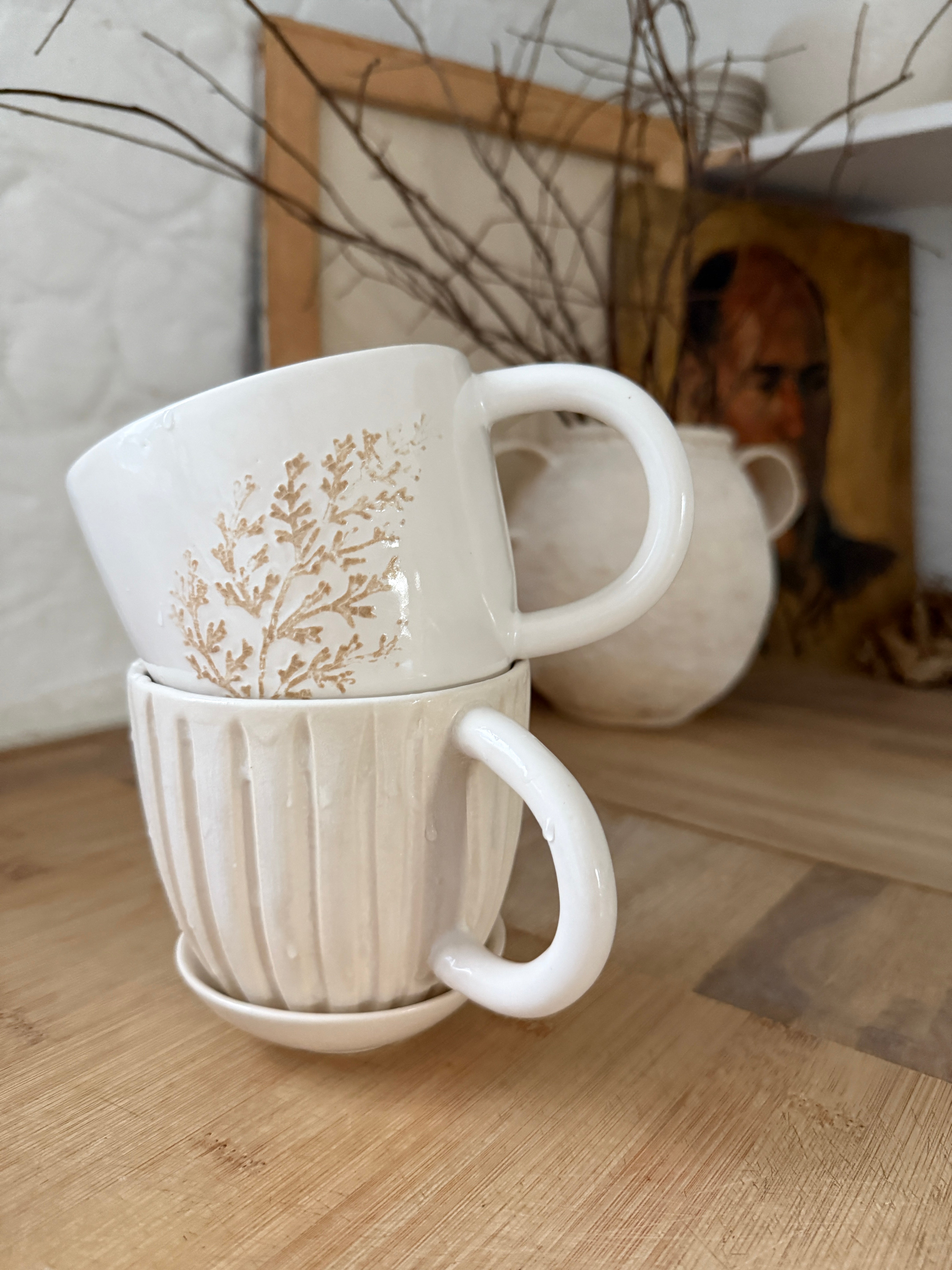 Handmade ceramic coffee mug with hand-carved vertical column lines and a glossy white interior.