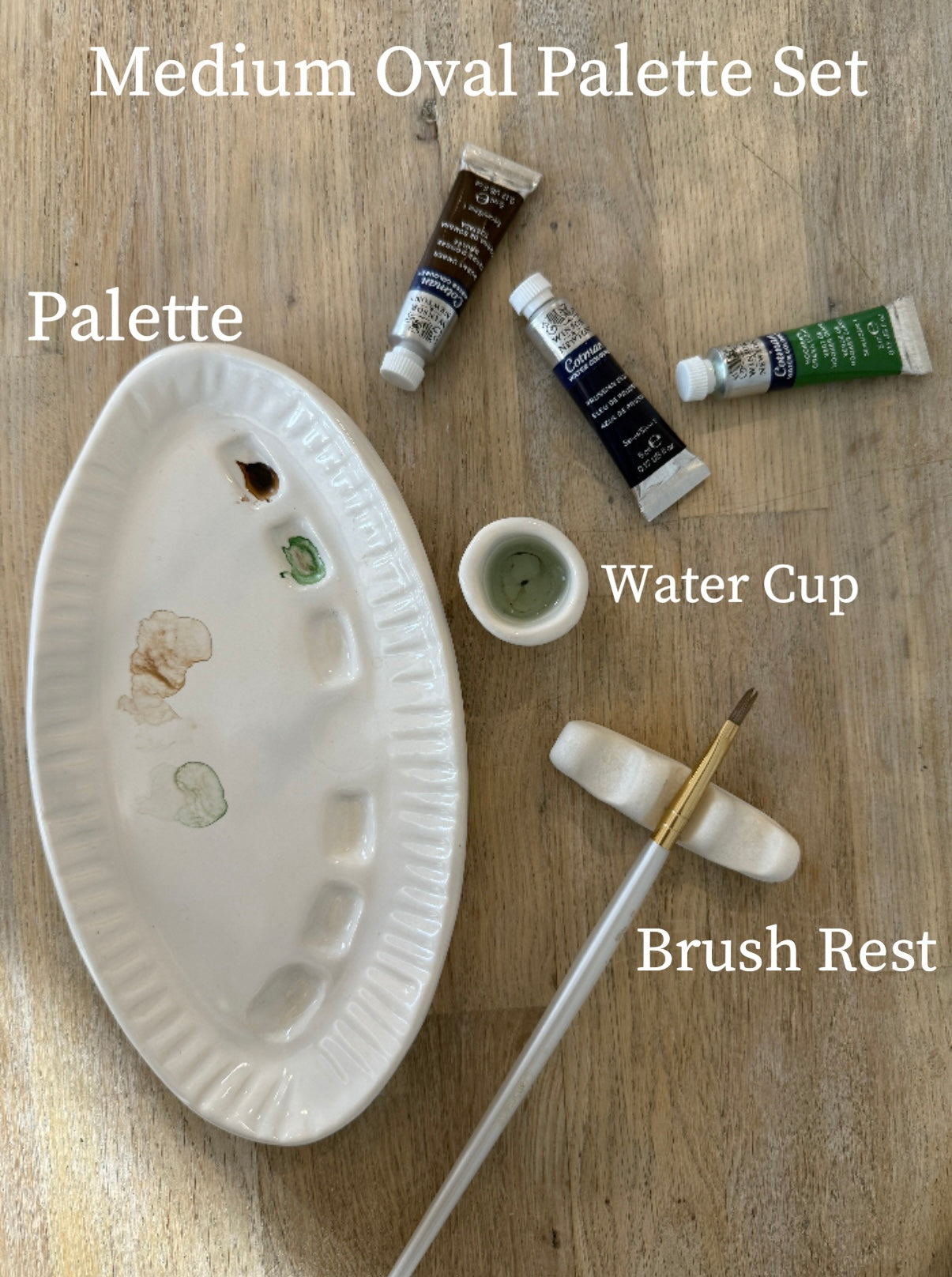 Handmade ceramic watercolor paint palette with mixing wells, a small water cup, and a brush holder.