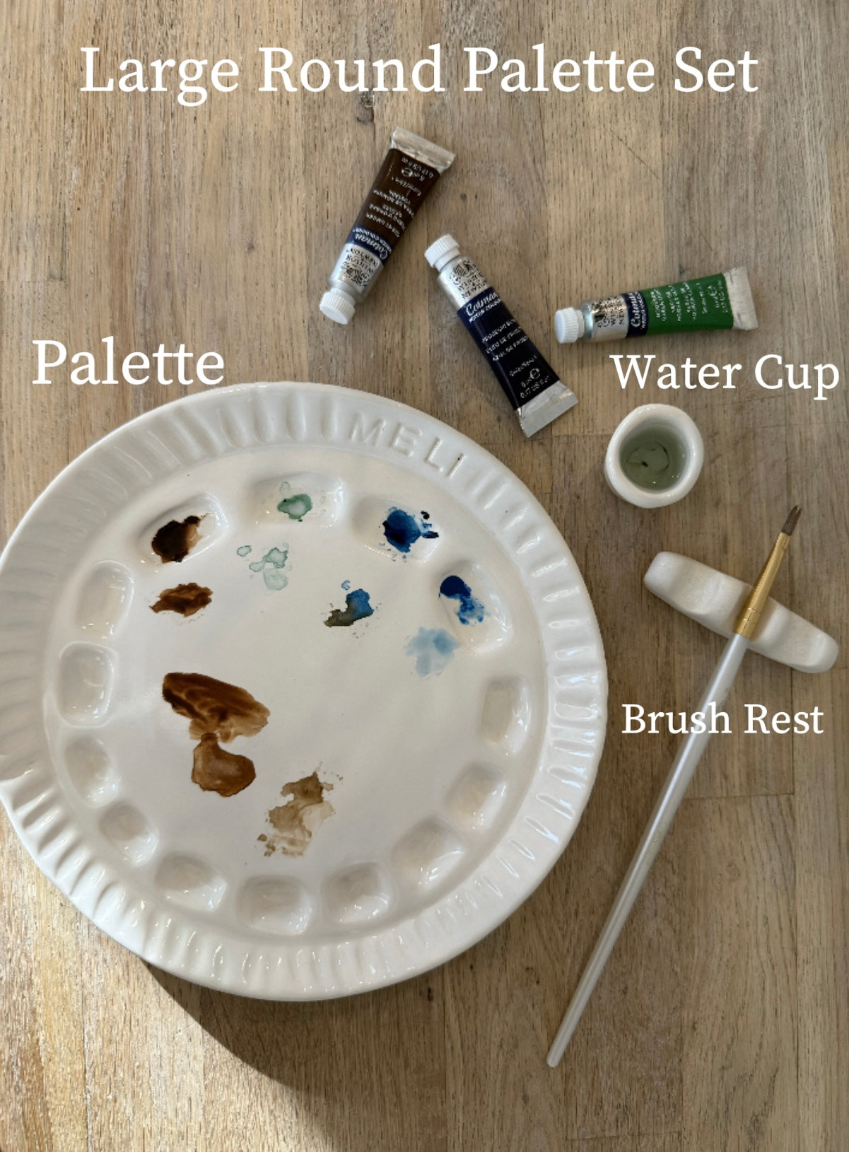 Handmade ceramic watercolor paint palette with mixing wells, a small water cup, and a brush holder.