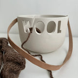 Handmade ceramic yarn bowl with smooth white interior and natural clay exterior finish