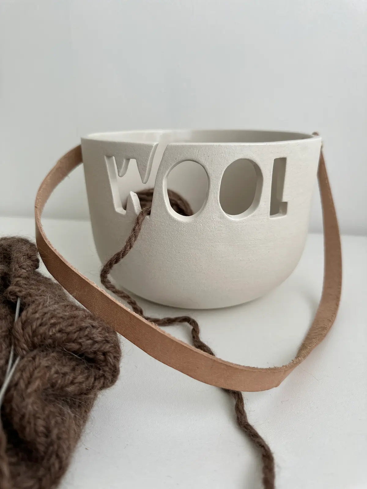 Handmade ceramic yarn bowl with smooth white interior and natural clay exterior finish