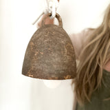 Large campana-style ceramic bell hanging from a rope