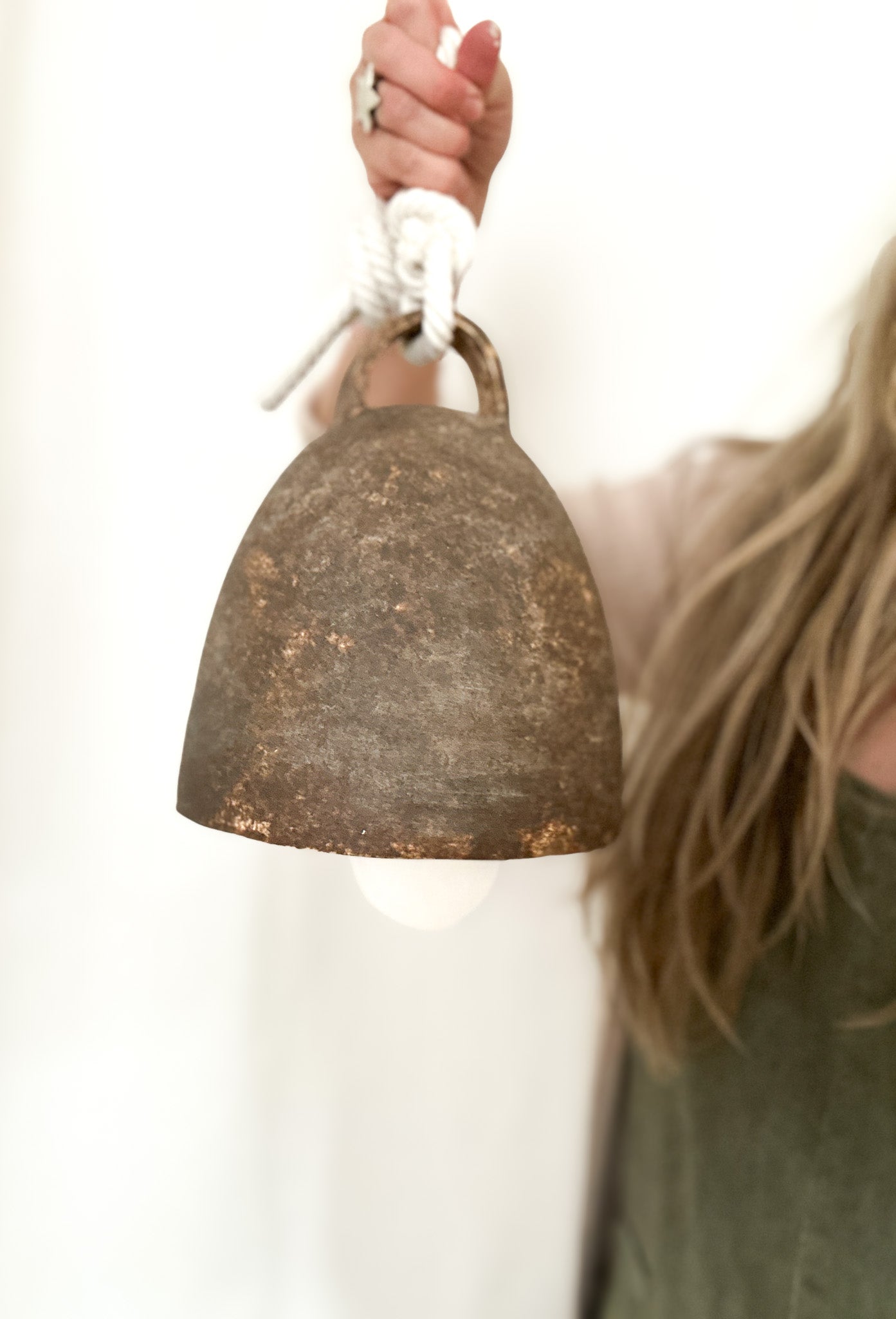 Large campana-style ceramic bell hanging from a rope