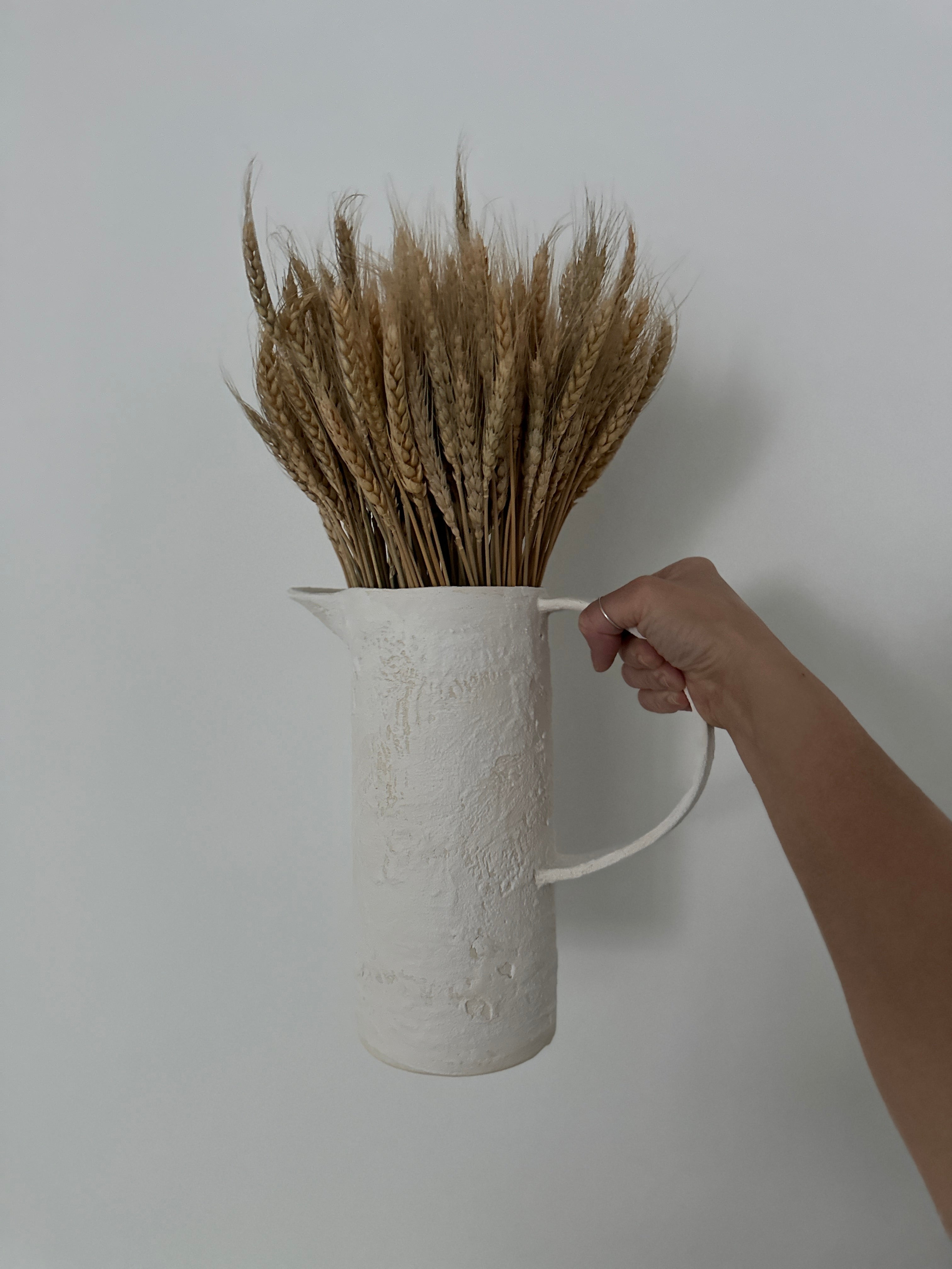 Handmade stoneware pitcher with a large looped handle for easy pouring