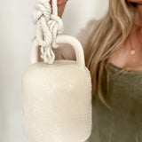 Handmade textured white ceramic barrel bell with rope, a thoughtful housewarming gift