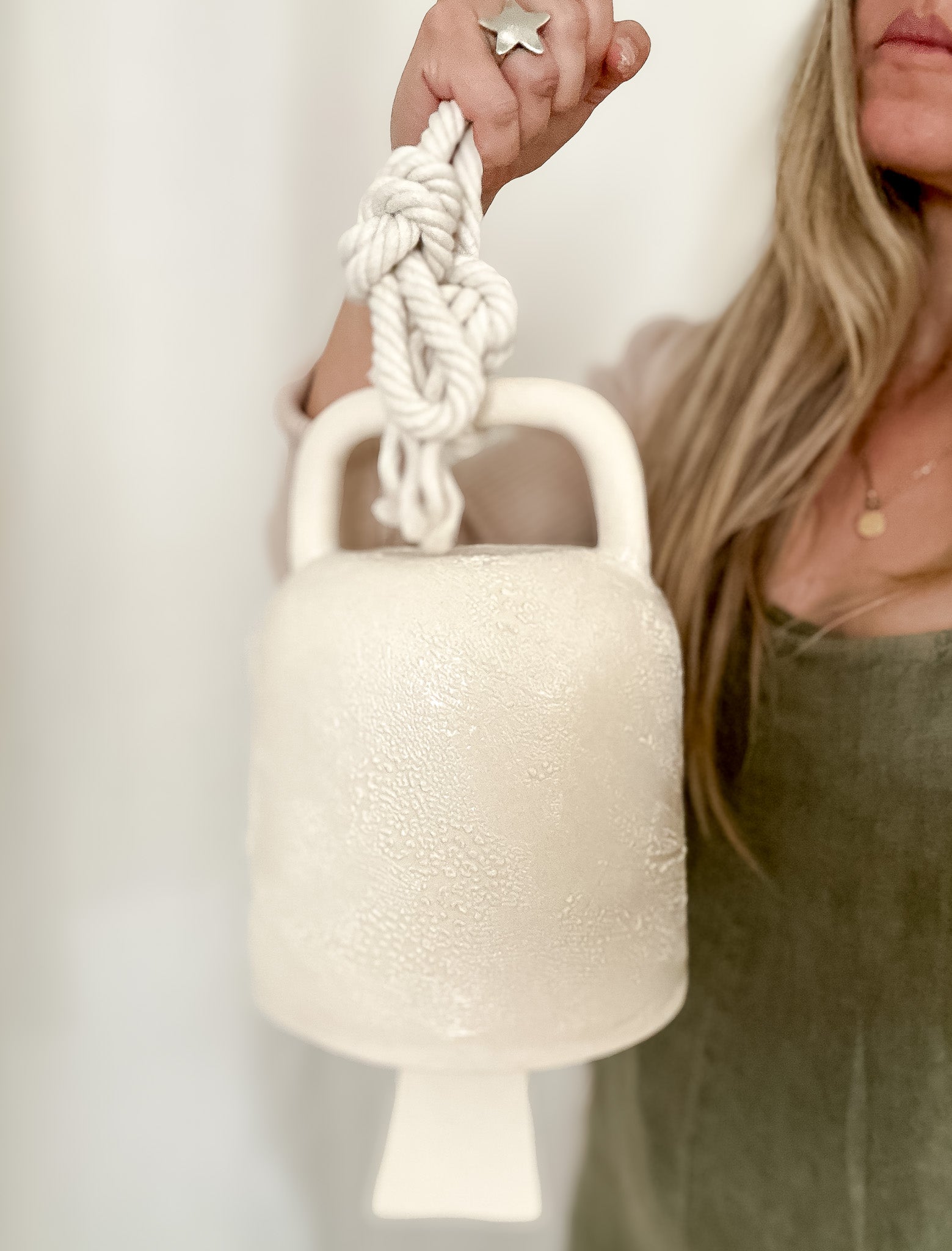 Handmade ceramic barrel bell with rope in a textured white glaze, for minimalist interiors