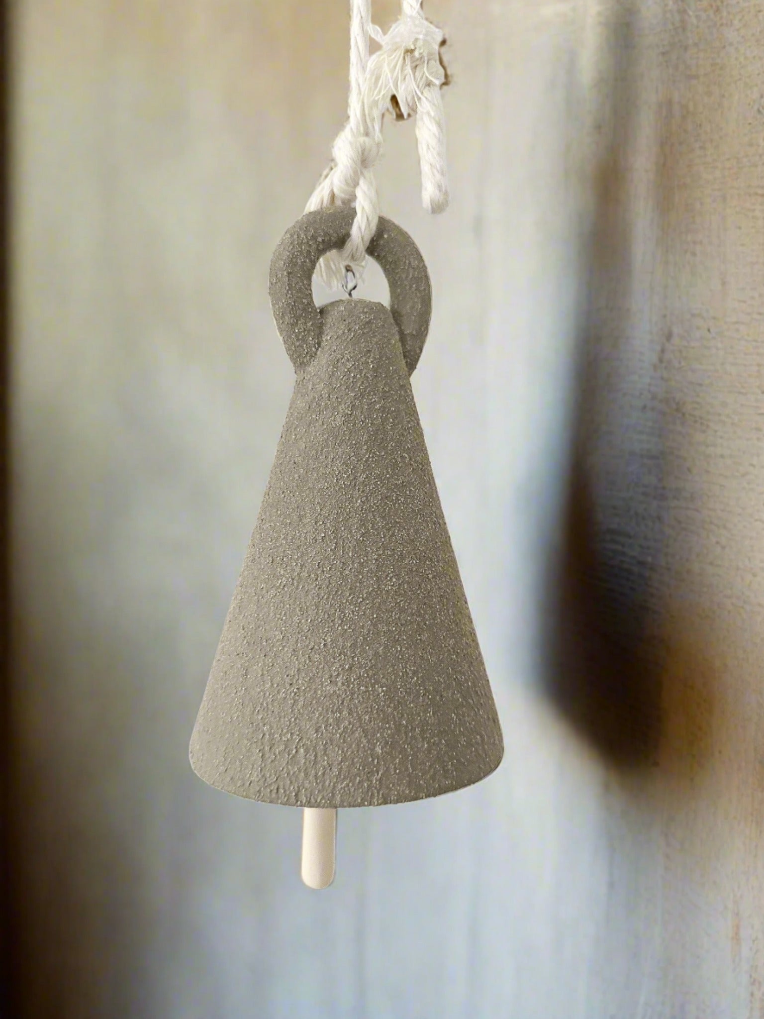 Tall spire-shaped ceramic bell, side view
