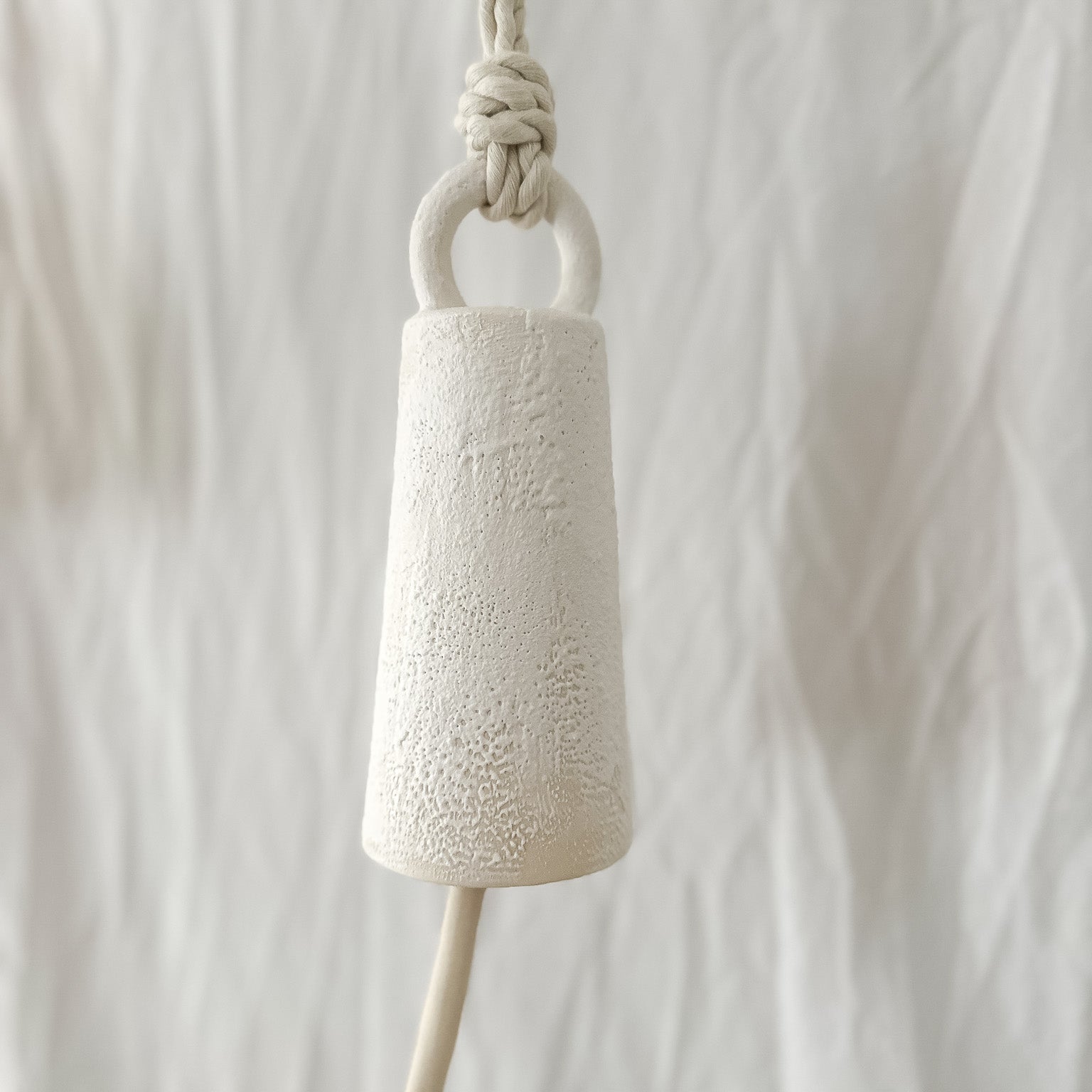 Handmade ceramic spotlight bell with a rounded silhouette in a neutral glaze