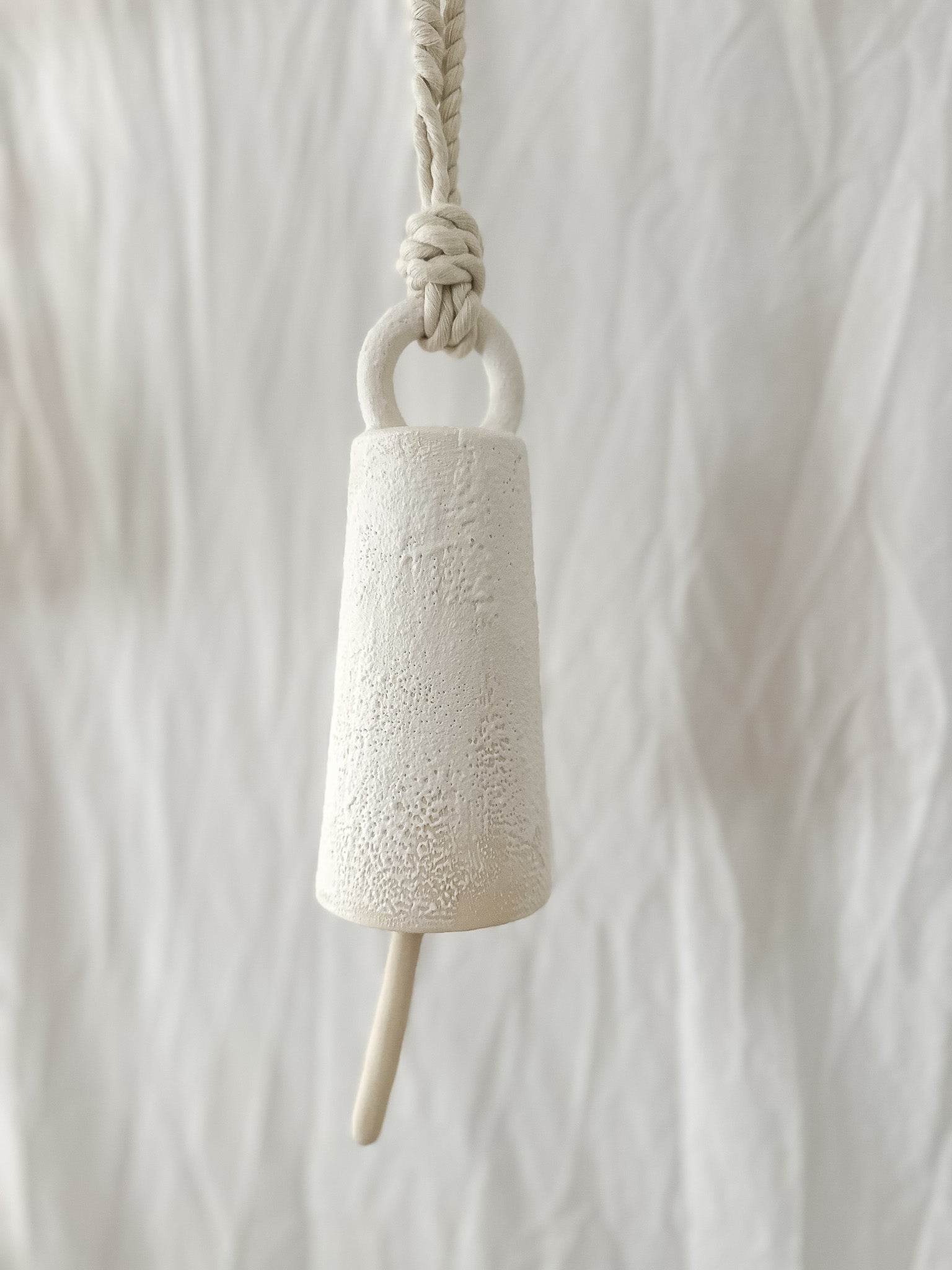 Handmade ceramic spotlight bell with a rounded silhouette in a neutral glaze