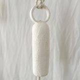 Long round-handle ceramic bell styled on a porch