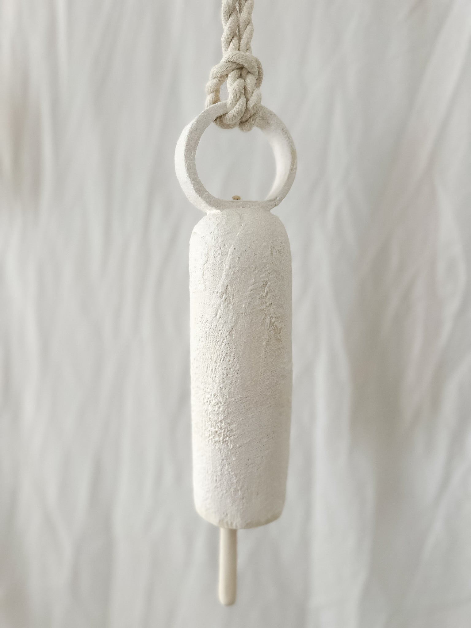 Long round-handle ceramic bell styled on a porch