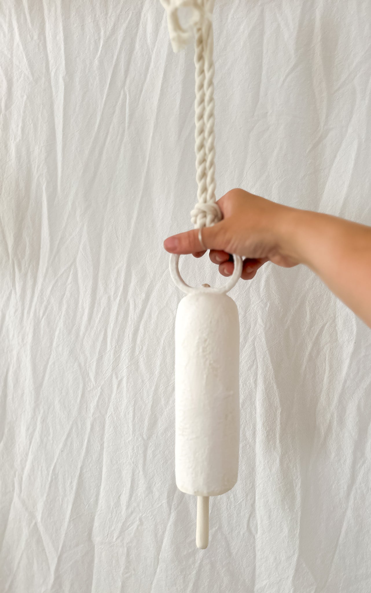 Ceramic wall bell with a rounded handle, side view