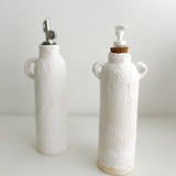 Handmade ceramic oil and soap dispenser bottles grouped together