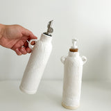 Neutral ceramic dispenser bottles, close-up of the pump top