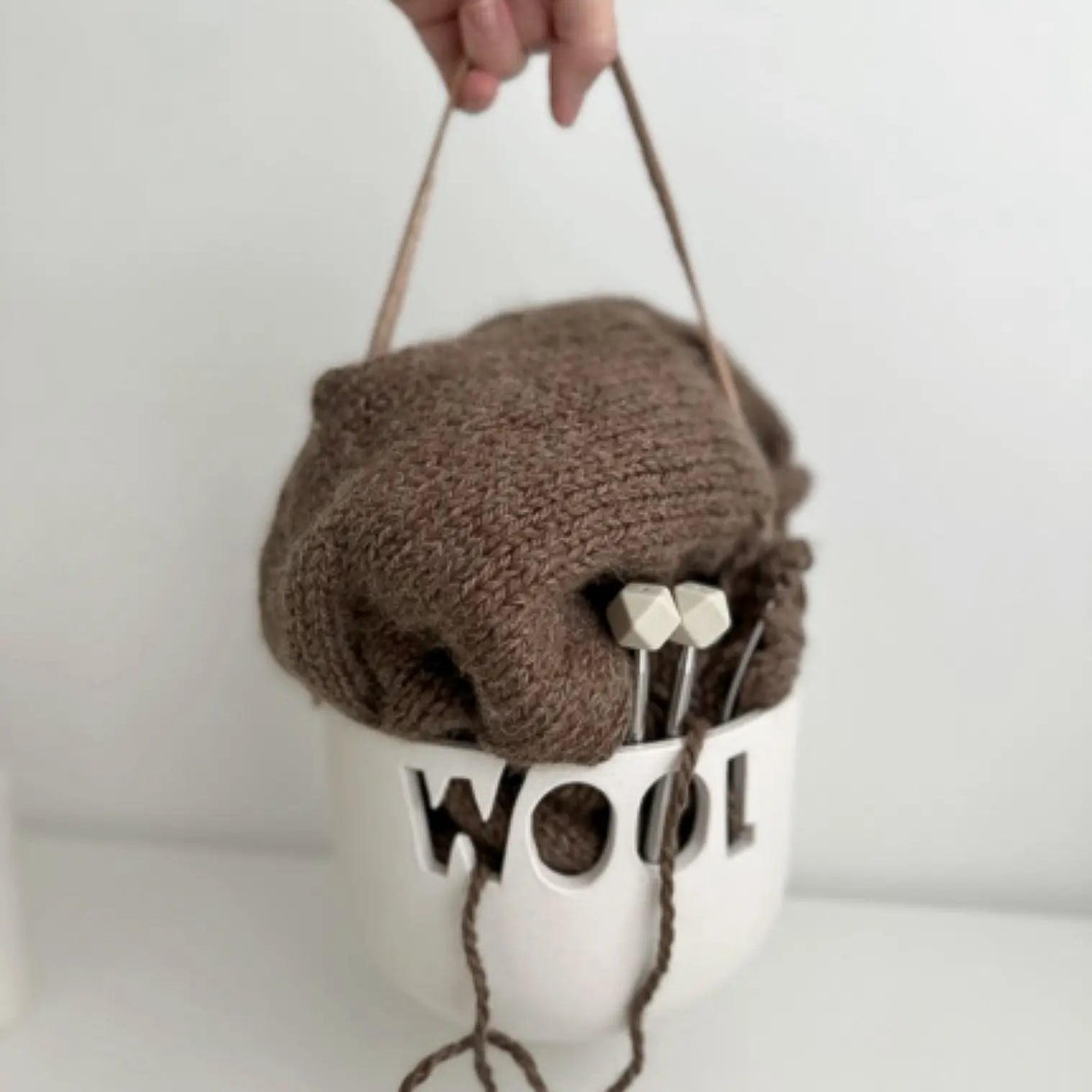 Handmade ceramic knitting yarn bowl with a leather handle and curved slot for tangle-free yarn