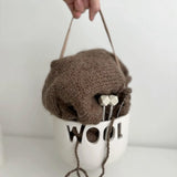 Handmade ceramic knitting yarn bowl with a leather handle and curved slot for tangle-free yarn