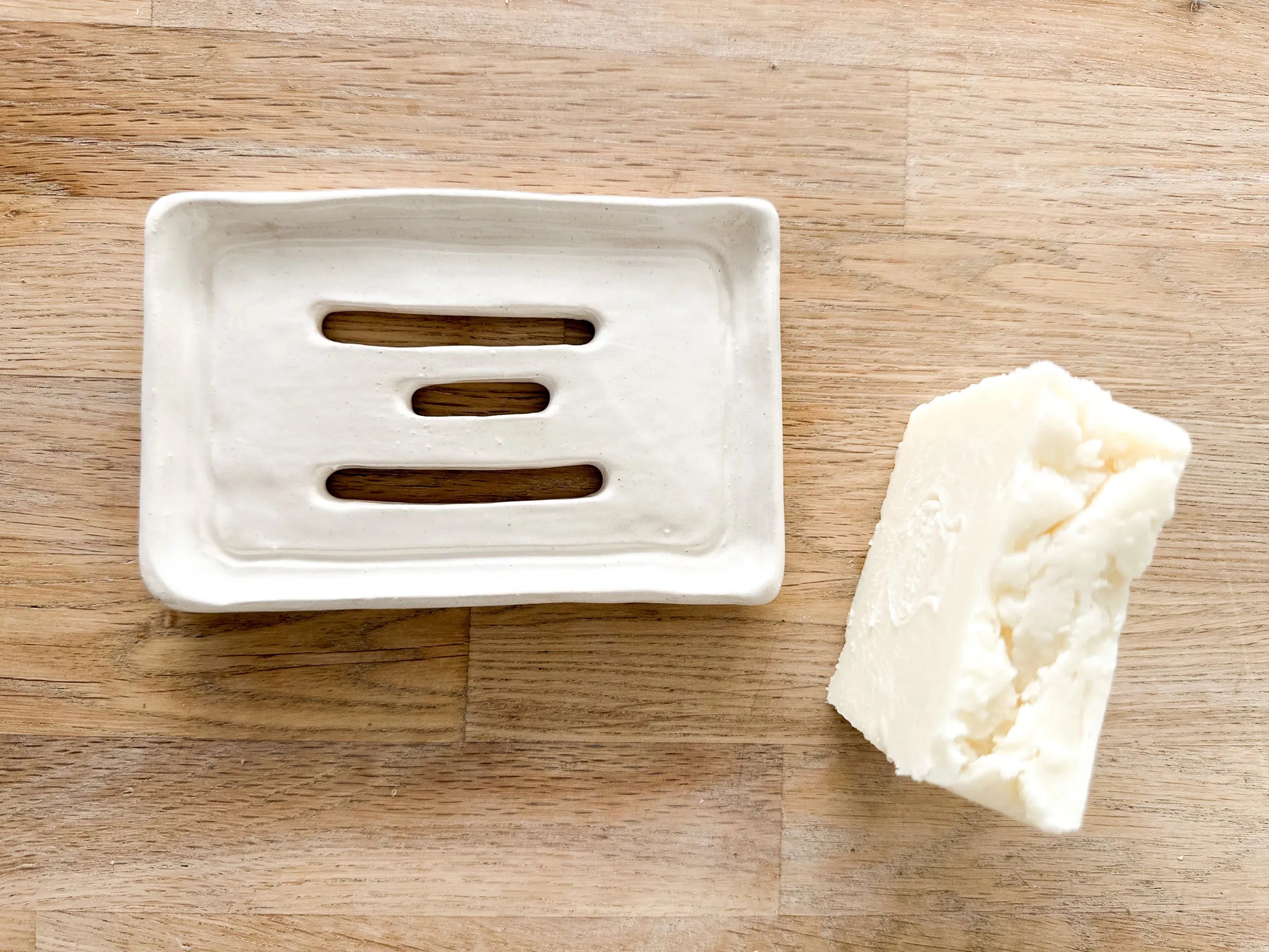 Neutral ceramic soap dish with a drainage design for the sink