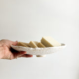 Wide handmade ceramic stand dish used as a table centerpiece
