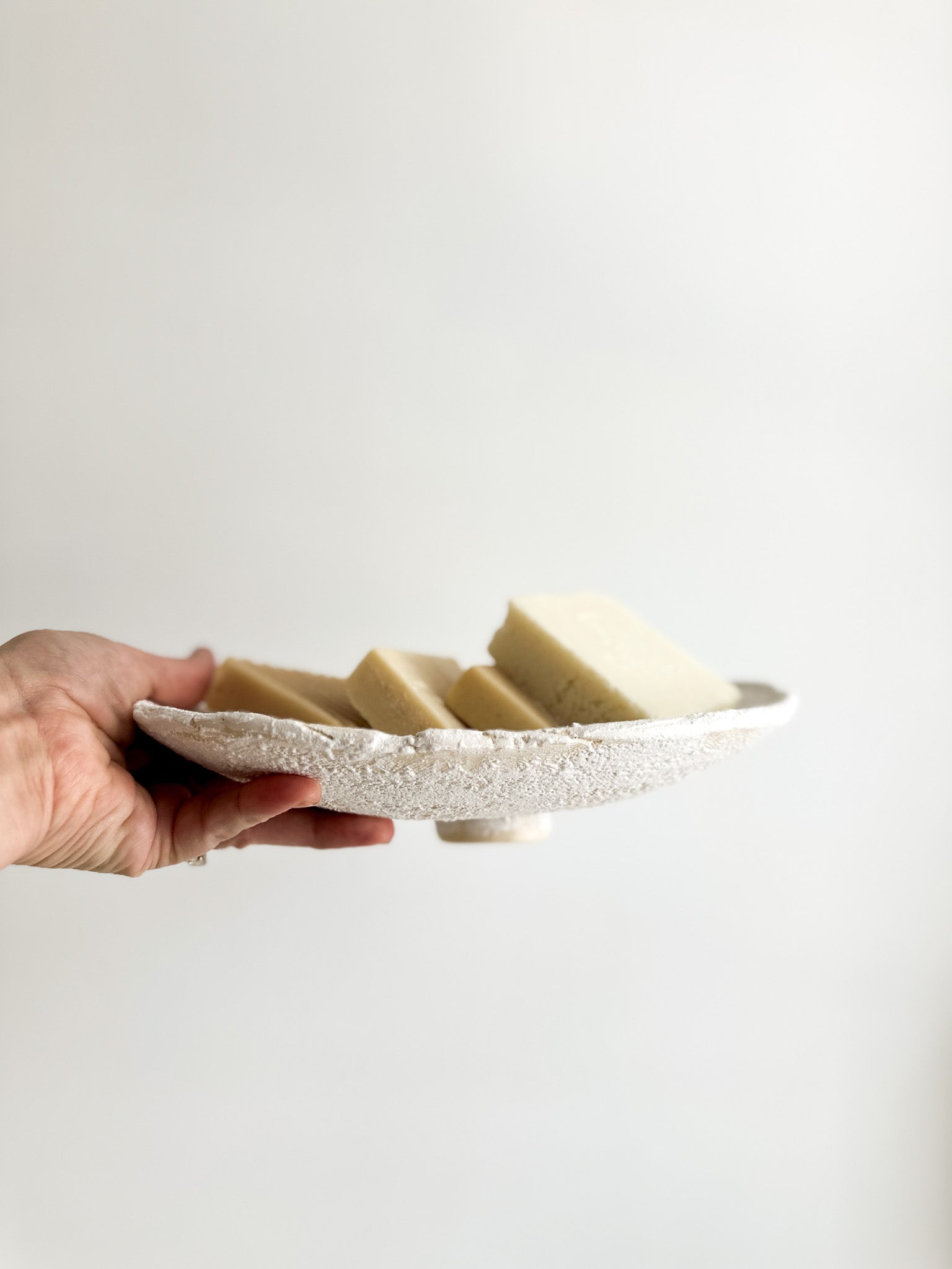 Wide handmade ceramic stand dish used as a table centerpiece