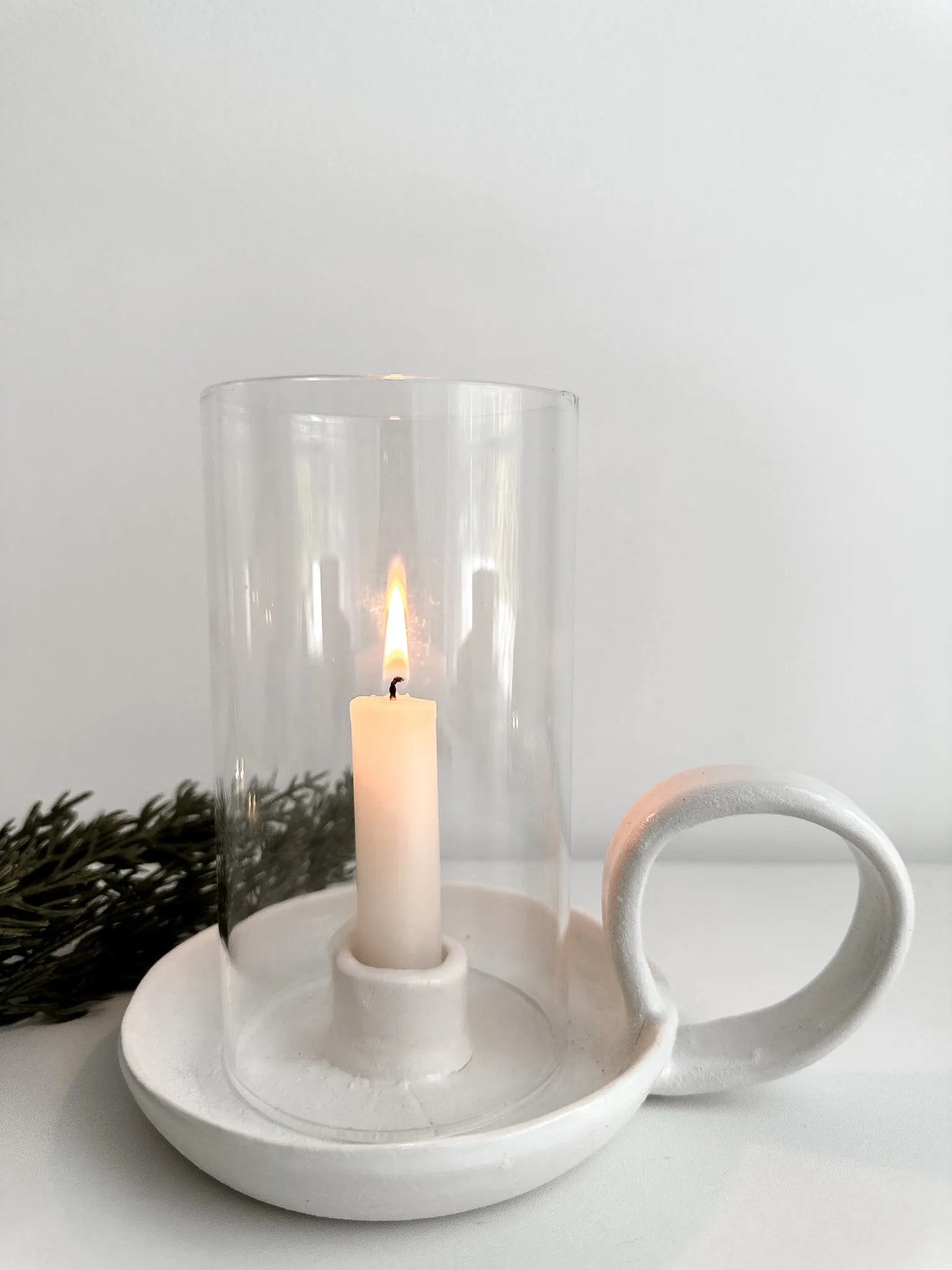 Textured white ceramic candle holder with handle and glass cover, ideal for mediterranean and european farmhouse interiors. This handmade piece makes a unique gift for housewarmings, weddings, or any special occasion