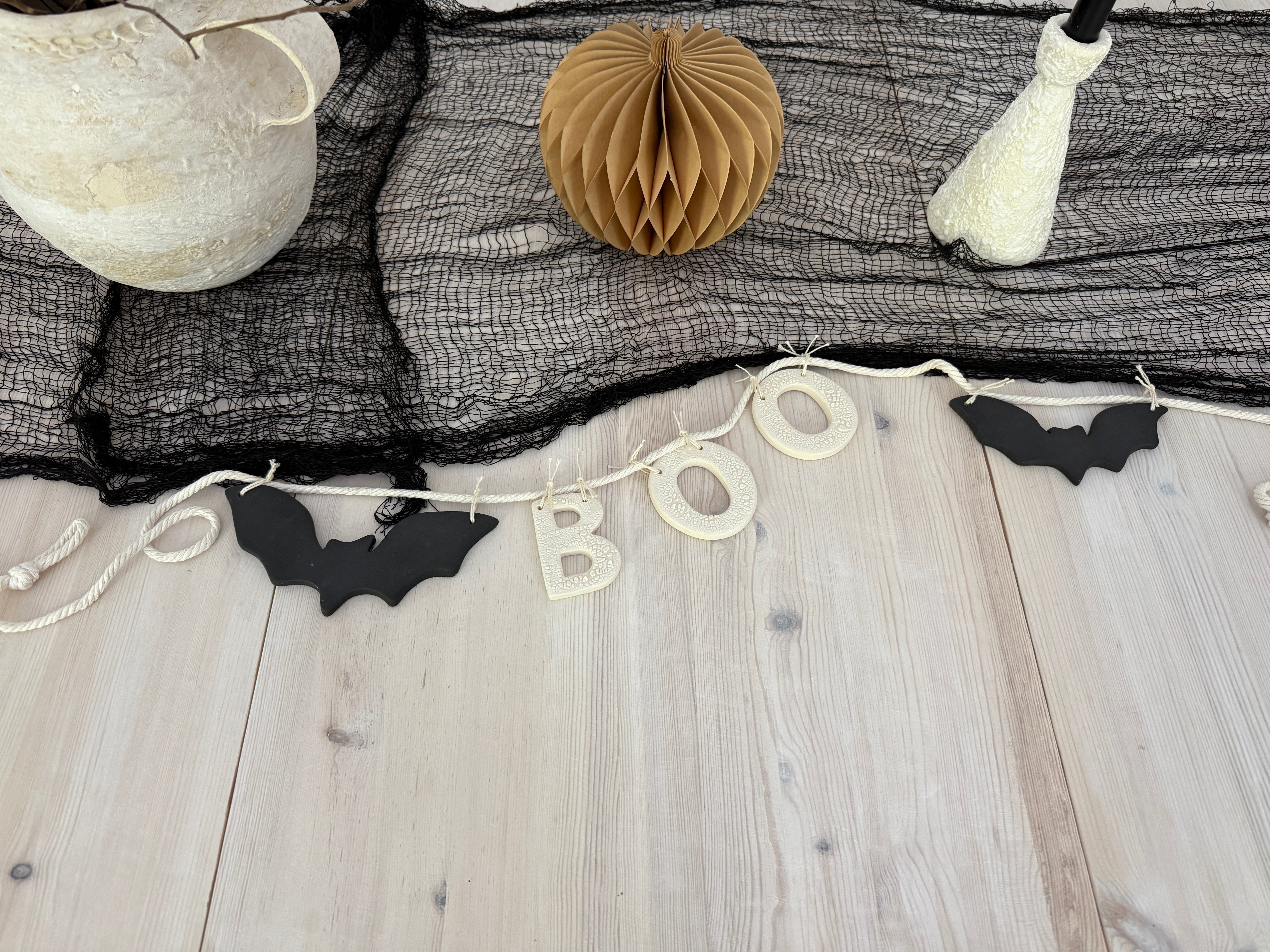 Handmade stoneware garland spelling BOO in ceramic letters on natural cotton rope.