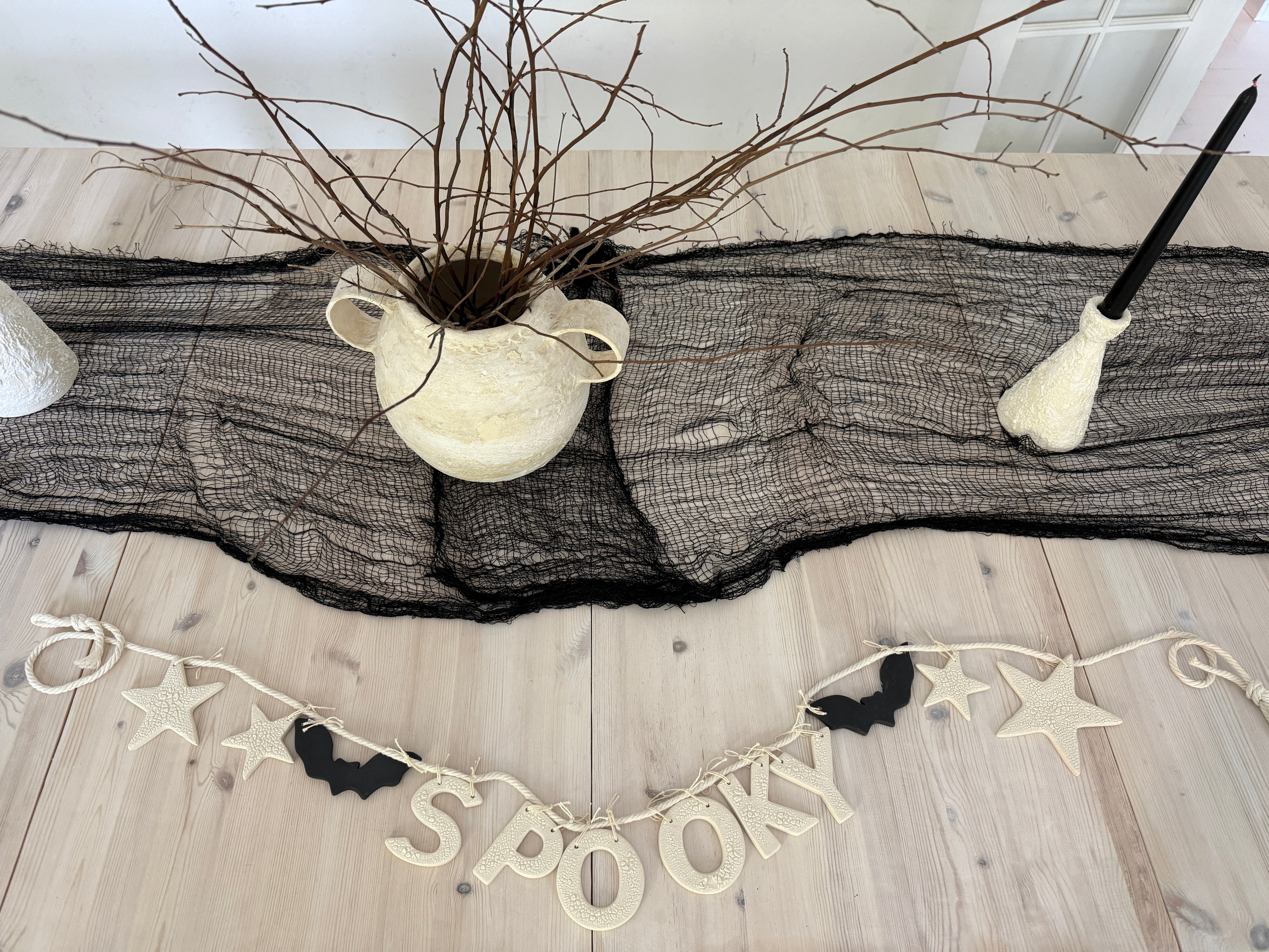Handmade stoneware Halloween garland spelling SPOOKY on natural cotton rope in neutral tones.