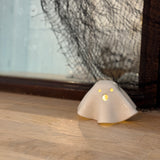 Handmade ceramic ghost luminary glowing softly with an LED tealight candle.