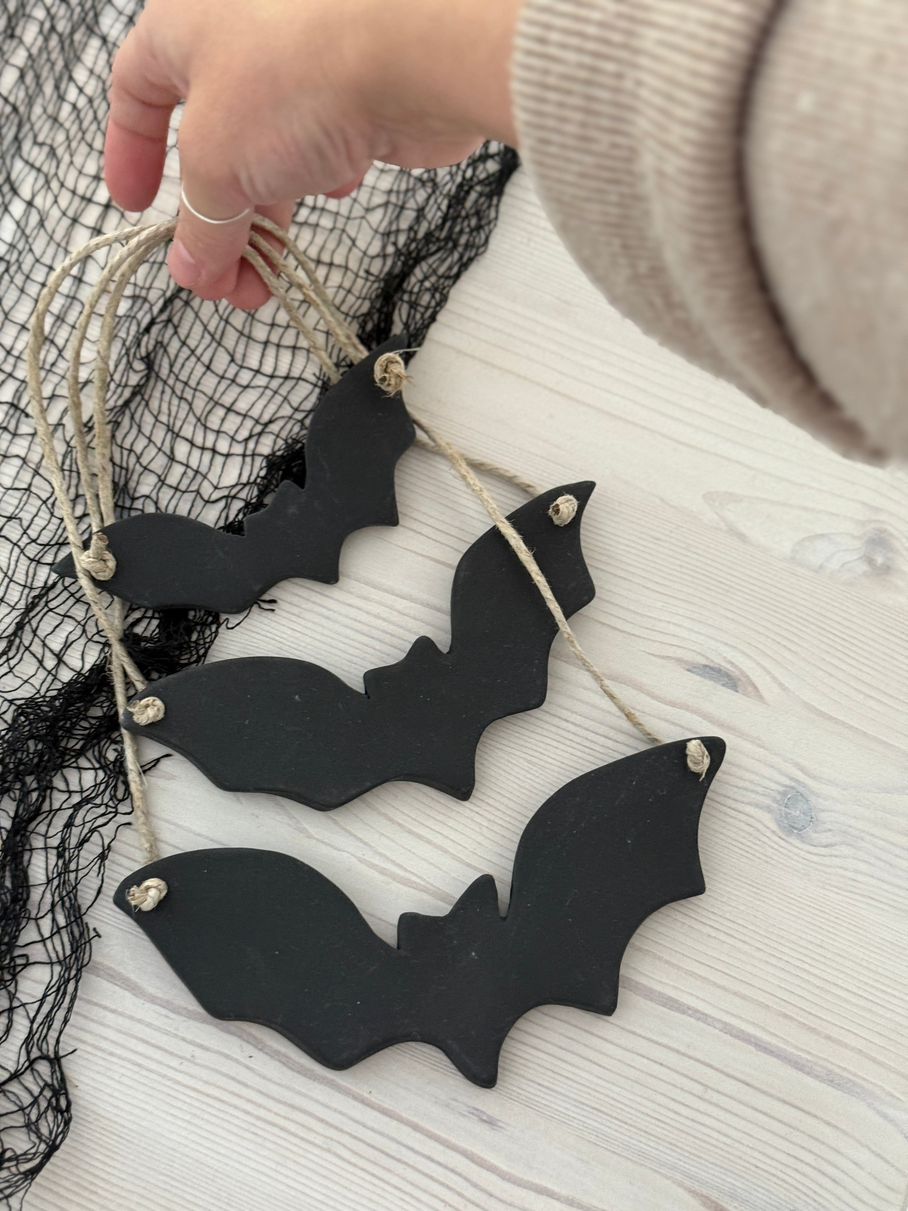 Handmade stoneware bat ornaments in three sizes for hanging on knobs, branches, or wreaths.