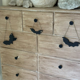 Handmade stoneware bat ornaments in three sizes for hanging on knobs, branches, or wreaths.