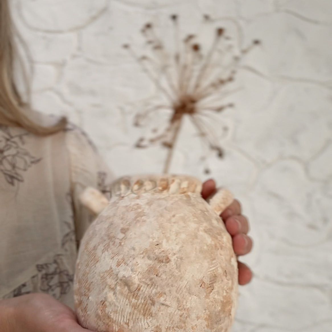 Handmade wild clay ceramic handled jar with a textured natural surface and glazed interior.