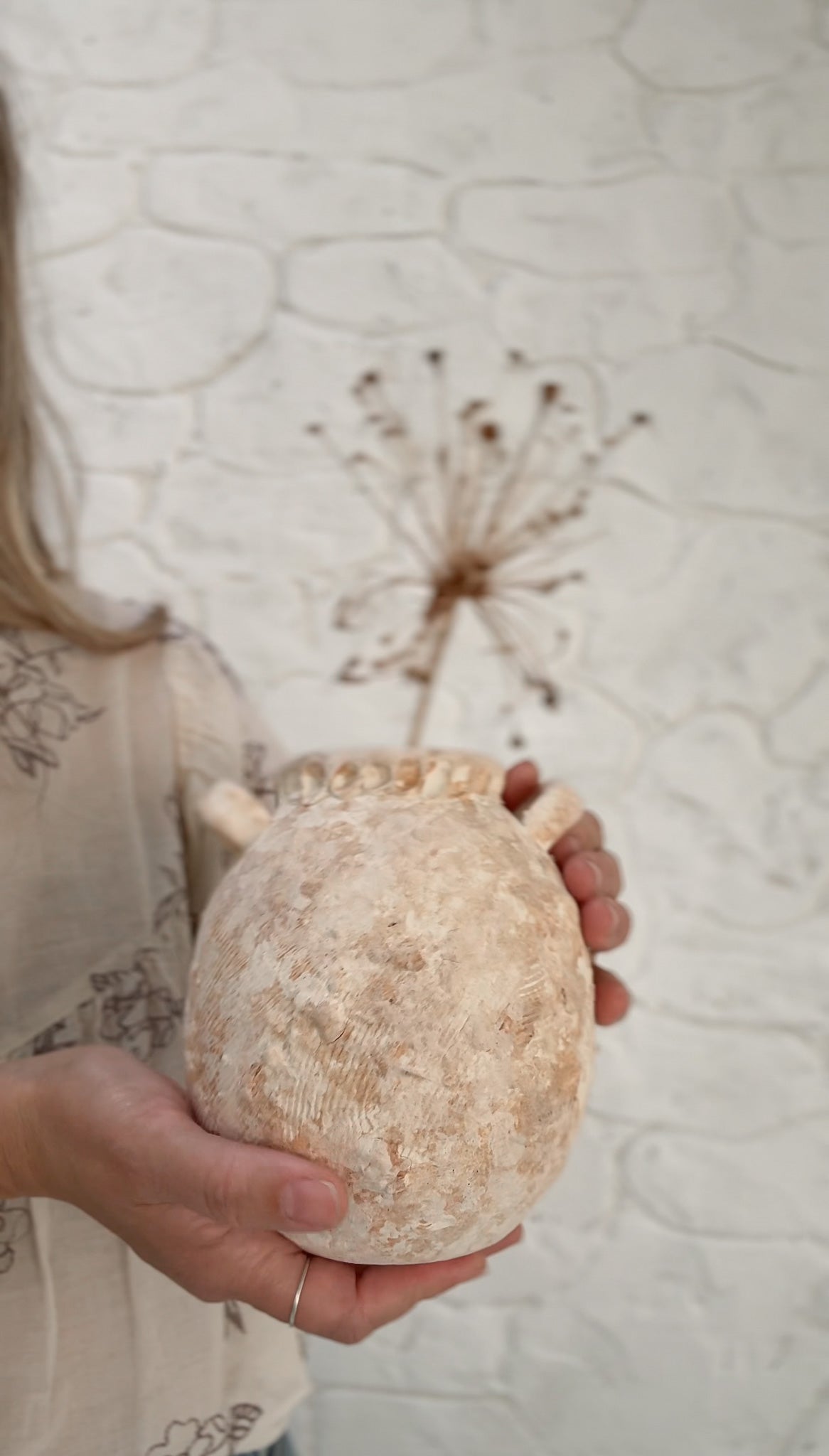 Handmade wild clay ceramic handled jar with a textured natural surface and glazed interior.