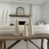 Handmade stoneware tree luminary with star cutouts glowing from an LED tea light