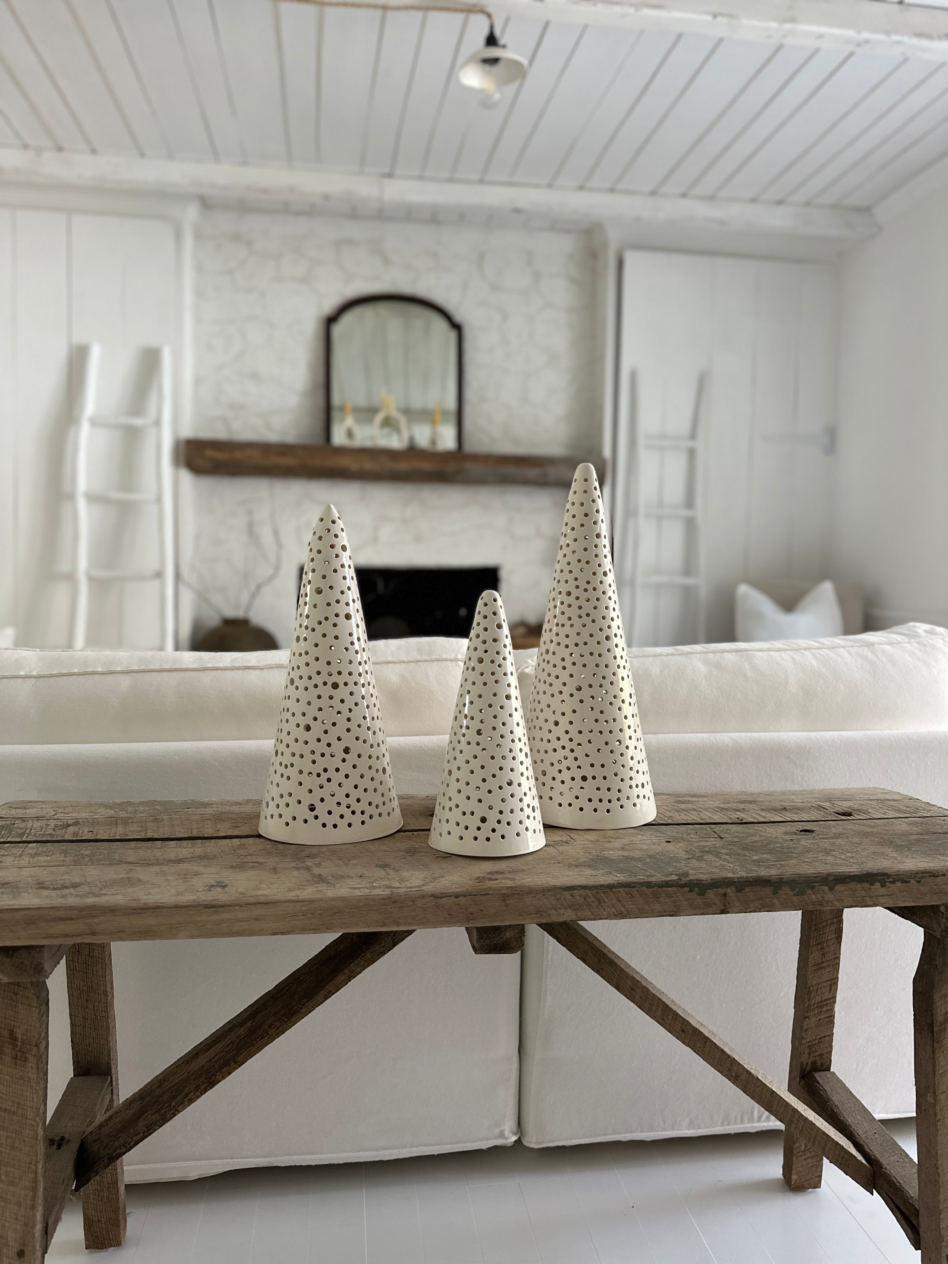 Handmade stoneware tree luminary with star cutouts glowing from an LED tea light