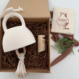 Handmade ceramic bell paired with a solid wood wall peg, styled as a gift set.
