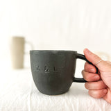 Assorted handmade ceramic mugs with textured glazes, dishwasher-safe seconds-sale pieces from Muddy Heart