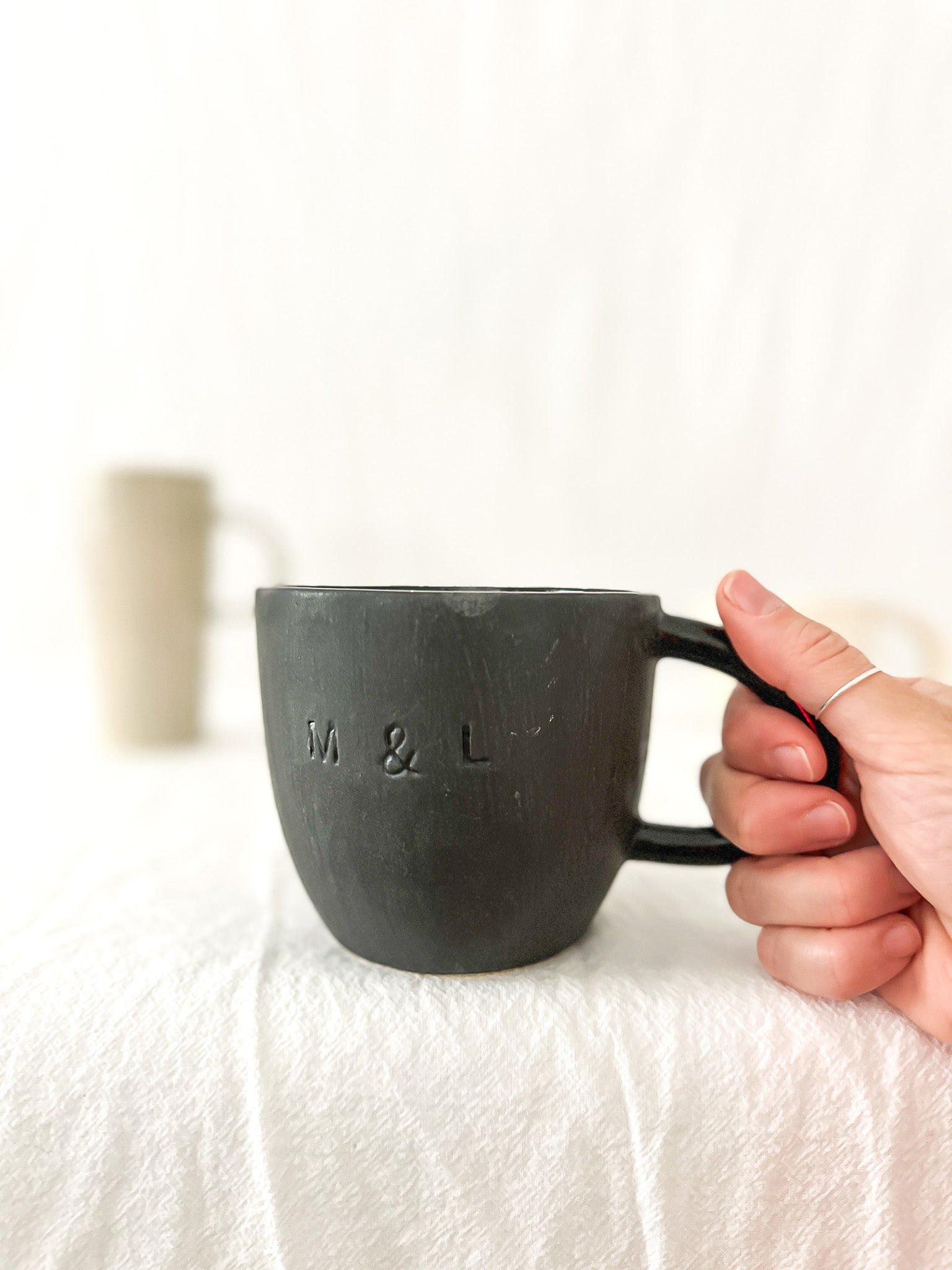 Assorted handmade ceramic mugs with textured glazes, dishwasher-safe seconds-sale pieces from Muddy Heart